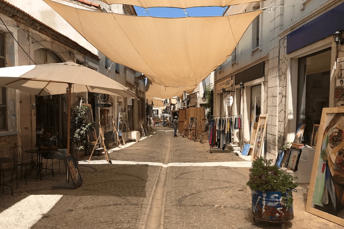 Open-air art market on a cobbled Urla street